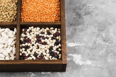 Fasulye ürün yelpazesine (kırmızı mercimek, yeşil mercimek, nohut, bezelye, Kuru fasulye, fasulye, mix fasulye, mung fasulye) gri arka plan üzerinde. Uzay kopyalayın. Gıda arka plan