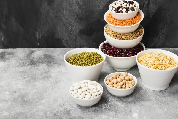 Fasulye ürün yelpazesine (kırmızı mercimek, yeşil mercimek, nohut, bezelye, Kuru fasulye, fasulye, mix fasulye, mung fasulye) gri arka plan üzerinde. Uzay kopyalayın. Gıda arka plan