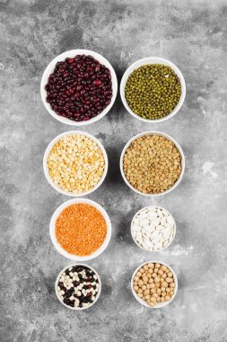 Fasulye ürün yelpazesine (kırmızı mercimek, yeşil mercimek, nohut, bezelye, Kuru fasulye, fasulye, mix fasulye, mung fasulye) gri arka plan üzerinde. Üstten görünüm. Gıda arka plan