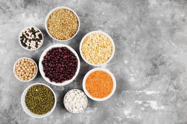 Fasulye ürün yelpazesine (kırmızı mercimek, yeşil mercimek, nohut, bezelye, Kuru fasulye, fasulye, mix fasulye, mung fasulye) gri arka plan üzerinde. Görünümü en çok, uzay kopyalayın. Gıda arka plan