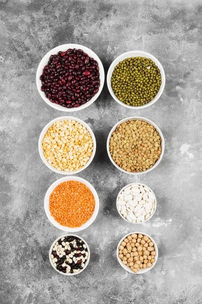 Fasulye ürün yelpazesine (kırmızı mercimek, yeşil mercimek, nohut, bezelye, Kuru fasulye, fasulye, mix fasulye, mung fasulye) gri arka plan üzerinde. Üstten görünüm. Gıda arka plan