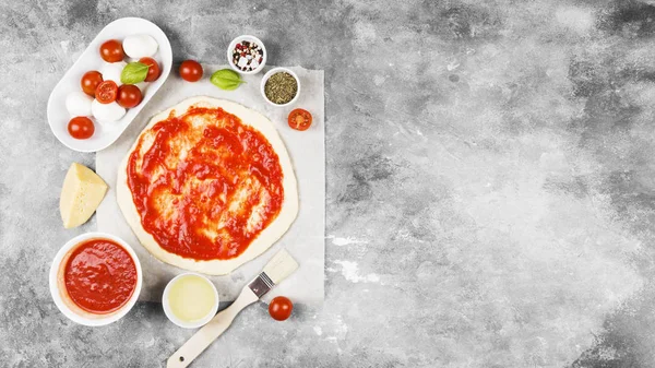Pizza hamur ve gri arka plan üzerinde pizza için malzemeler. Görünümü en çok, uzay kopyalayın. Gıda arka plan