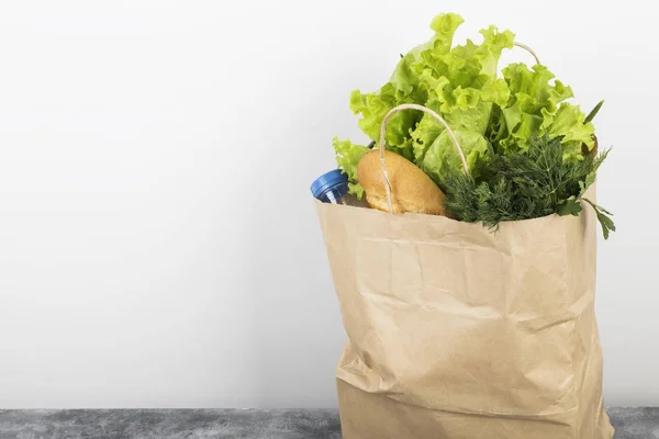 Various healthy food in paper bag on gray background. Copy space. Food background