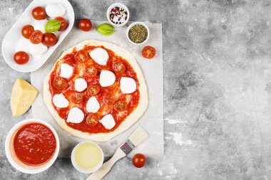 Pizza hamur ve gri arka plan üzerinde pizza için malzemeler. Görünümü en çok, uzay kopyalayın. Gıda arka plan