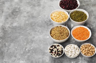 Fasulye ürün yelpazesine (kırmızı mercimek, yeşil mercimek, nohut, bezelye, Kuru fasulye, fasulye, mix fasulye, mung fasulye) gri arka plan üzerinde. Uzay kopyalayın. Gıda arka plan