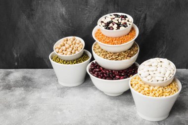 Fasulye ürün yelpazesine (kırmızı mercimek, yeşil mercimek, nohut, bezelye, Kuru fasulye, fasulye, mix fasulye, mung fasulye) gri arka plan üzerinde. Uzay kopyalayın. Gıda arka plan