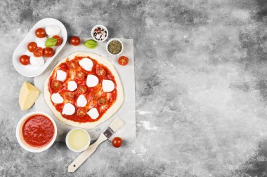 Pizza hamur ve gri arka plan üzerinde pizza için malzemeler. Görünümü en çok, uzay kopyalayın. Gıda arka plan
