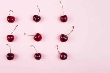 Olgun kiraz pembe bir arka plan üzerinde. Görünümü en çok, uzay kopyalayın. Gıda arka plan