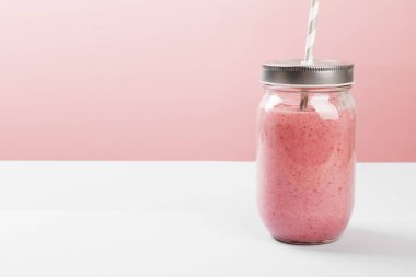 Çilek smoothies pembe bir arka plan üzerinde. Uzay kopyalayın. Gıda arka plan