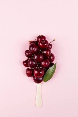 Olgun kiraz dondurma dondurmayı pembe bir arka plan üzerinde şeklinde. Üstten görünüm. Gıda arka plan