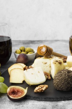 Şarap - peynir, incir, fındık, bal, üzüm gri bir arka plan üzerinde çeşitli aperatifler