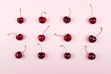 Olgun kiraz pembe bir arka plan üzerinde. Üstten görünüm. Gıda arka plan