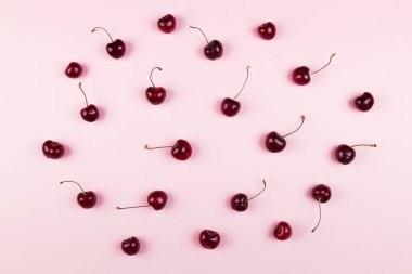 Olgun kiraz pembe bir arka plan üzerinde. Üstten görünüm. Gıda arka plan