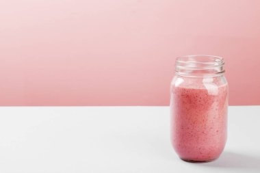 Çilek smoothies pembe bir arka plan üzerinde. Uzay kopyalayın. Gıda arka plan