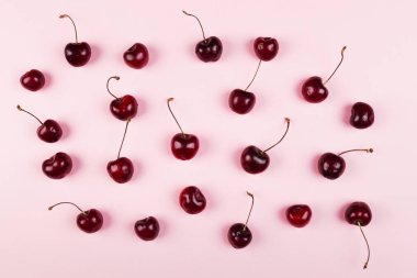 Olgun kiraz pembe bir arka plan üzerinde. Üstten görünüm. Gıda arka plan