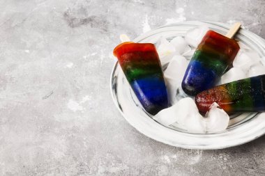 Gökkuşağı buzlu şeker gri bir arka plan üzerinde dondurma. Uzay kopyalayın. Gıda arka plan