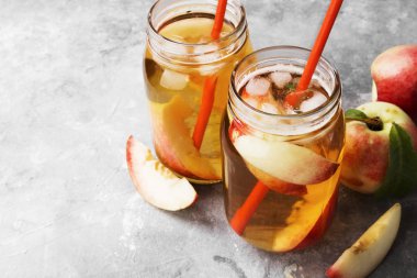 Gri bir arka plan üzerinde şeftalili buzlu çay. Uzay kopyalayın. Gıda arka plan