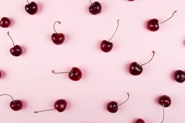 Olgun kiraz pembe bir arka plan üzerinde. Üstten görünüm. Gıda arka plan