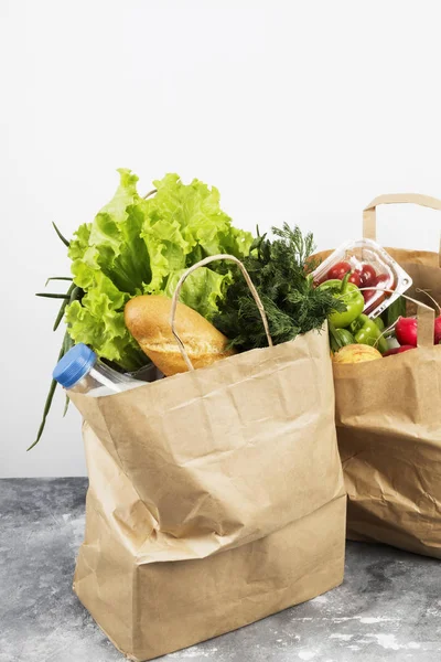 Various healthy food in paper bag on gray background