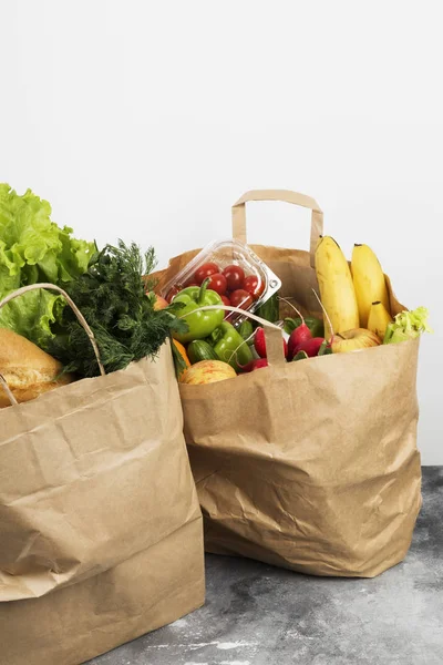 Various healthy food in paper bag on gray background