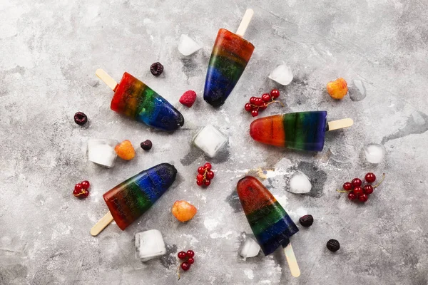 Rainbow ice cream popsicle on a gray background. Top view. Food background