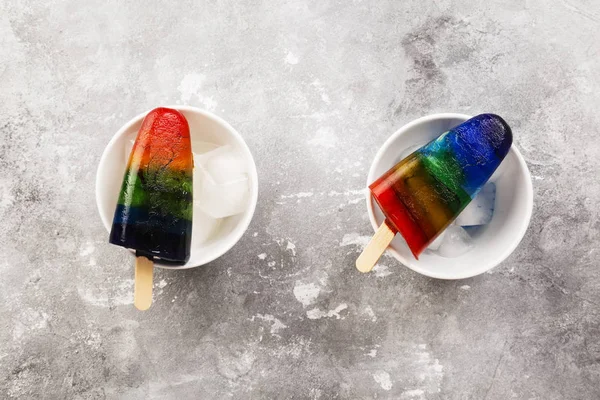 Rainbow ice cream popsicle on a gray background. Top view. Food background