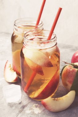 Gri bir arka plan üzerinde şeftali buzlu çay. Tonda