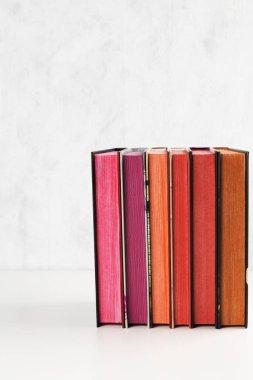 Beyaz arka plan üzerinde renk yığını ile kitap yığını. Kopyalama alanı