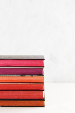 Beyaz arka plan üzerinde renk yığını ile kitap yığını. Kopyalama alanı