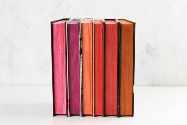Beyaz arkaplanda renk yığını olan kitap yığını
