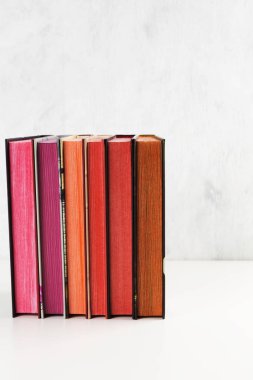 Beyaz arka plan üzerinde renk yığını ile kitap yığını. Kopyalama alanı