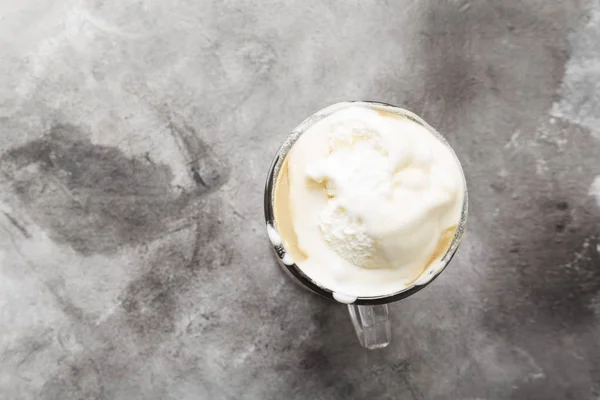 Ice coffee with ice cream on gray background. Top view, copy spa