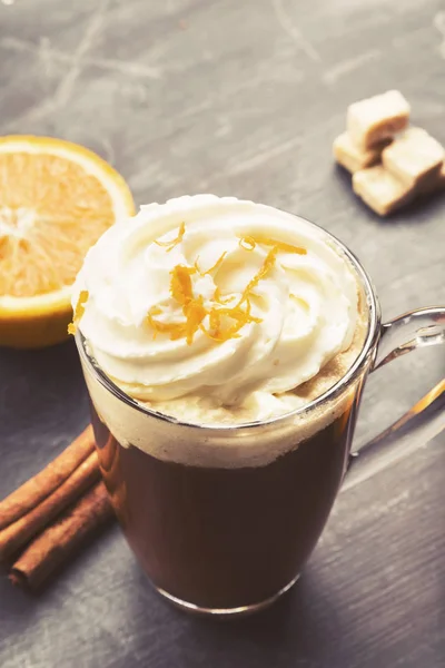 Autumn drink of coffee with orange juice and cream on dark backg