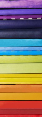 Beyaz arka plan üzerinde renkli gökkuşağı kitap yığını