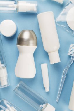 Seyahat küçük şişe mavi bir arka plan üzerinde ayarlayın. Üstte görüntü