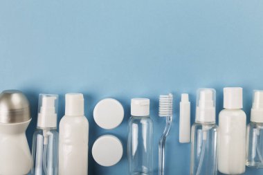 Seyahat küçük şişe pembe bir arka plan üzerinde ayarlayın. Üstte görünüm, kopya spa