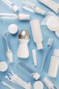 Seyahat küçük şişe mavi arka plan üzerinde ayarlayın. Üstte görüntü