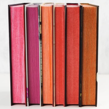 Beyaz arkaplanda renk yığını olan kitap yığını