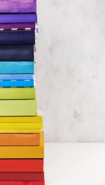 Beyaz arka plan üzerinde renkli gökkuşağı kitap yığını. Kopyalama alanı