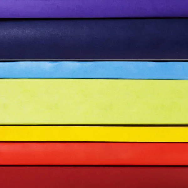 Куча разноцветных радужных книг на белом фоне — стоковое фото