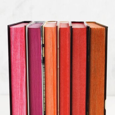 Beyaz arkaplanda renk yığını olan kitap yığını