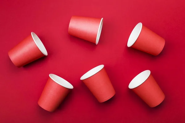 Red paper cups on red background. Top view