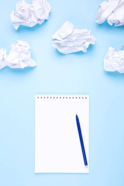 Beyaz defter ve kalem mavi arka planda buruşmuş kağıt etrafında bulutlar şeklinde. Dilek listesi ve hayaller çizme kavramı, bulutlara yönel