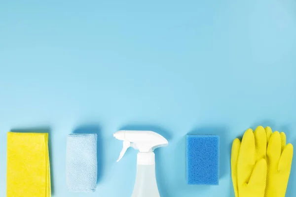 Detergents and cleaning products agent, sponges, napkins and rubber gloves, blue background. Top view. Copy space