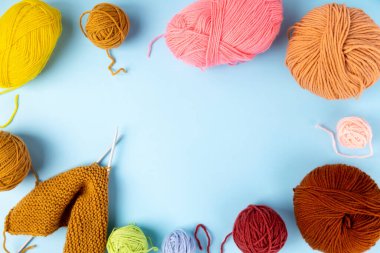 Örgü örmek için renkli iplik, mavi arka plan. Örgü projesi devam ediyor. Üst Manzara. Boşluğu kopyala