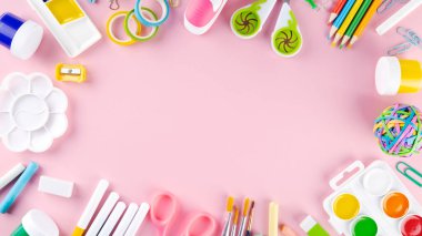 Çeşitli okul müdürlükleri ve pembe arka planda boya malzemeleri. Okul konseptine geri dönelim. Üst Manzara. Boşluğu kopyala