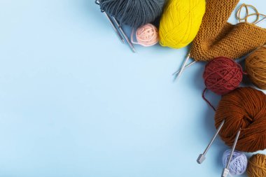 Örgü örmek için renkli iplik, mavi arka plan. Örgü projesi devam ediyor. Üst Manzara. Boşluğu kopyala