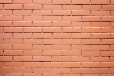 Açık kırmızı neredeyse pembe boya ile boyanmış dokulu tuğla duvar parçası