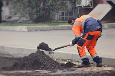 Tamirci asfaltı değiştirmek için çalışıyor.