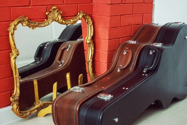 Gitar kılıfları ayna ve şöminenin yanında.